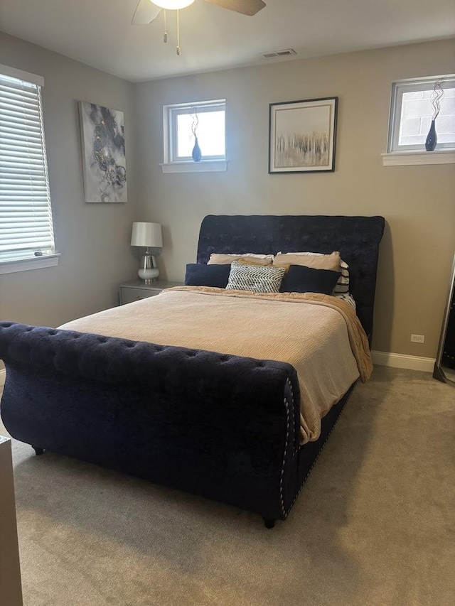 bedroom with multiple windows, light colored carpet, and ceiling fan