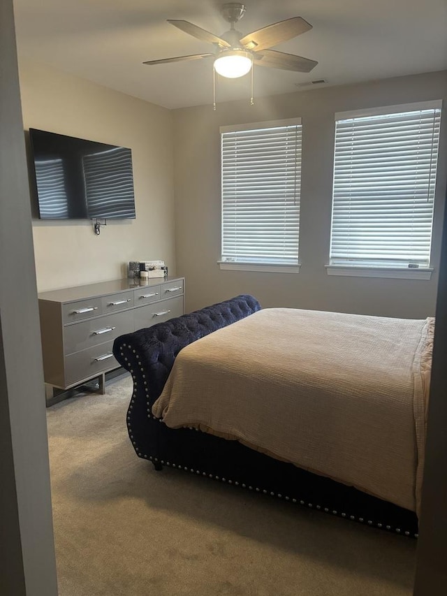 bedroom featuring light carpet and ceiling fan