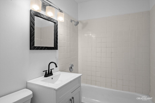 full bathroom featuring toilet, vanity, and tiled shower / bath