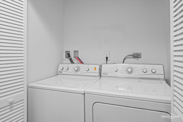 clothes washing area with washing machine and dryer