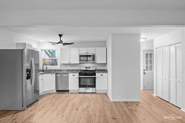 kitchen featuring white cabinetry, stainless steel appliances, light hardwood / wood-style floors, sink, and ceiling fan