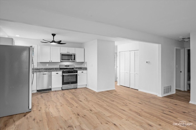 kitchen featuring ceiling fan, white cabinetry, stainless steel appliances, and light wood-type flooring