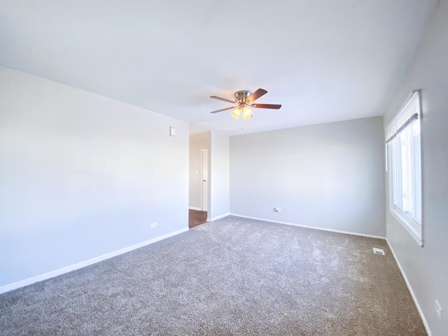 carpeted spare room featuring ceiling fan