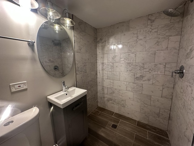 bathroom with vanity, toilet, and a tile shower