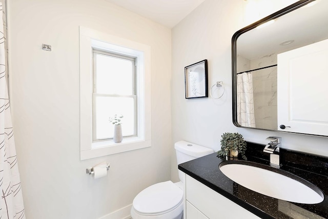 bathroom featuring a wealth of natural light, toilet, and vanity