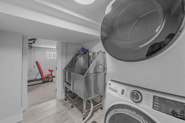 laundry area with stacked washer / dryer and light carpet