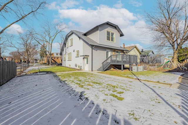 back of property with a lawn and a wooden deck