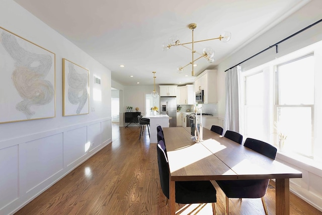 dining area featuring dark hardwood / wood-style flooring and a notable chandelier