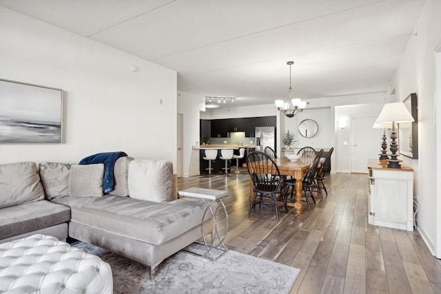 living room with dark hardwood / wood-style floors and a chandelier