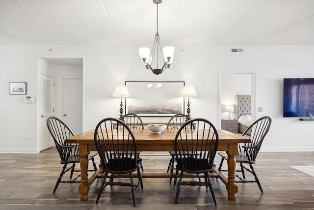 dining room featuring a notable chandelier and dark hardwood / wood-style flooring