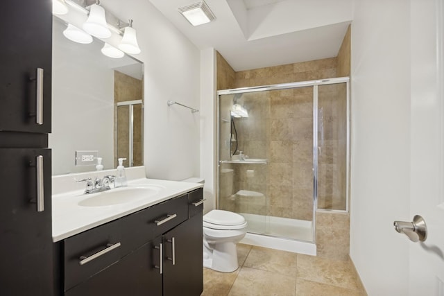 bathroom featuring tile patterned flooring, vanity, a shower with door, and toilet