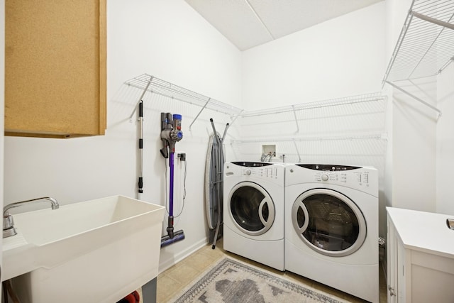 laundry area featuring washing machine and dryer, sink, and light tile patterned flooring