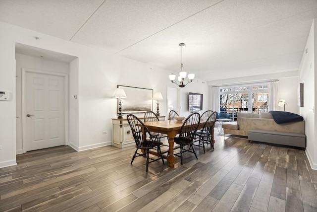 dining room with dark hardwood / wood-style floors, a notable chandelier, and a textured ceiling