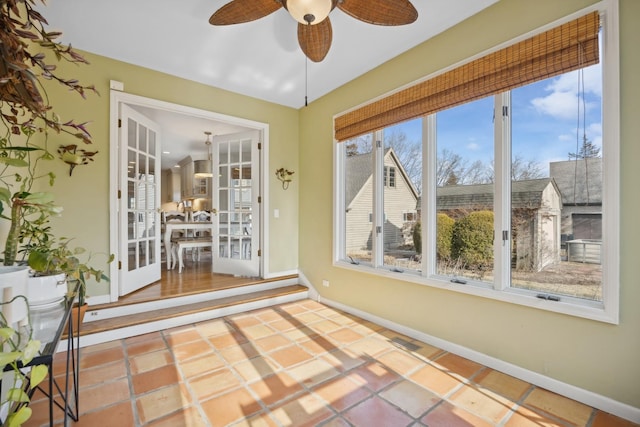 unfurnished sunroom with ceiling fan