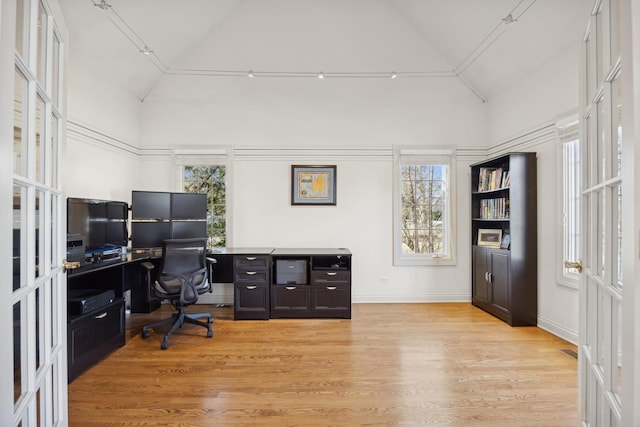 office space featuring light hardwood / wood-style flooring and high vaulted ceiling