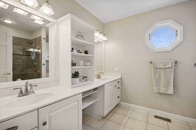 bathroom featuring a tile shower, vanity, and tile patterned floors