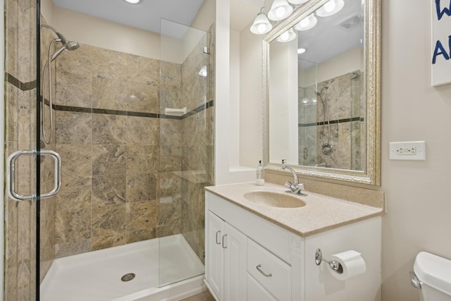 bathroom with vanity, toilet, and an enclosed shower