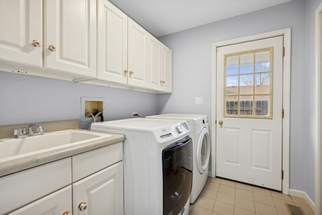 laundry room with sink, light tile patterned floors, cabinets, and washing machine and clothes dryer