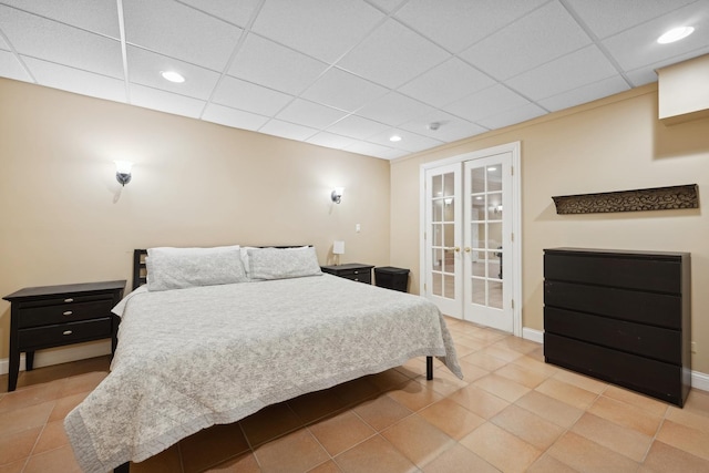 tiled bedroom featuring access to outside, a paneled ceiling, and french doors