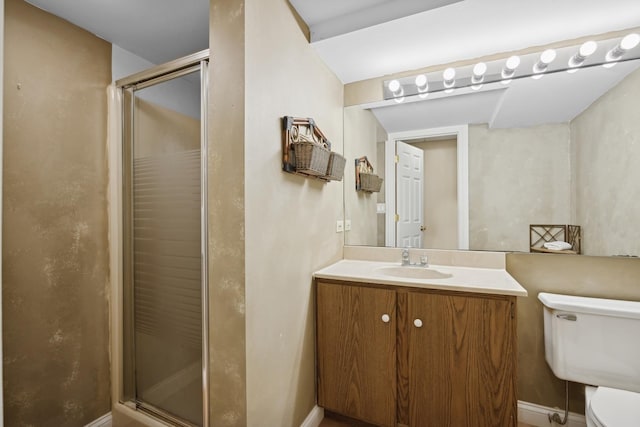 bathroom with vanity, toilet, and an enclosed shower