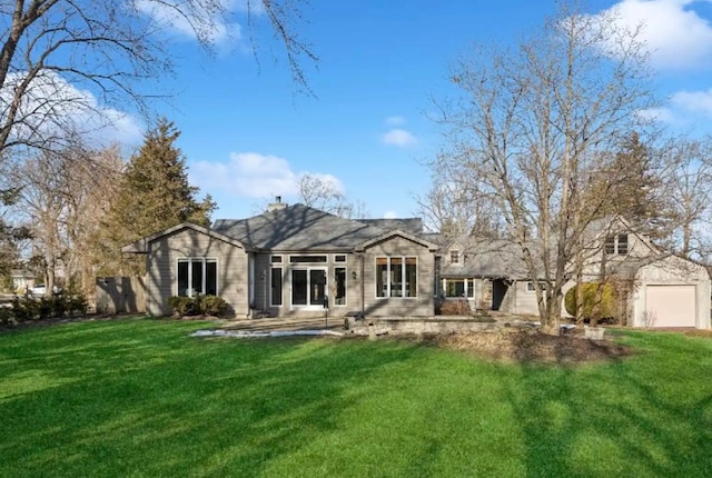 back of property with a garage and a yard