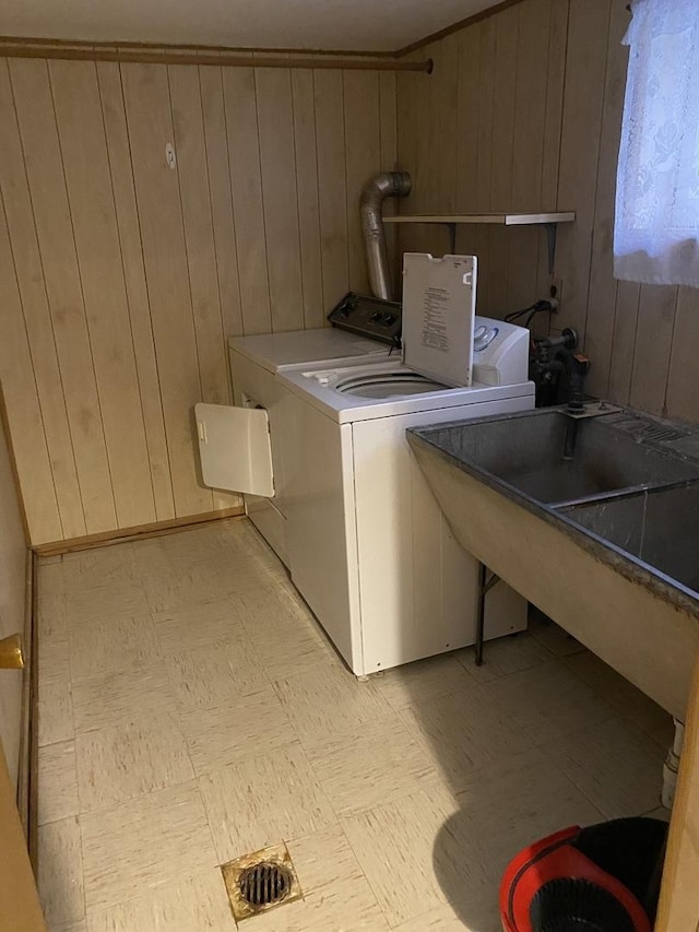 laundry room with washer and dryer and wood walls