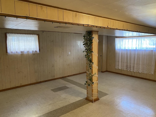 basement featuring plenty of natural light and wood walls