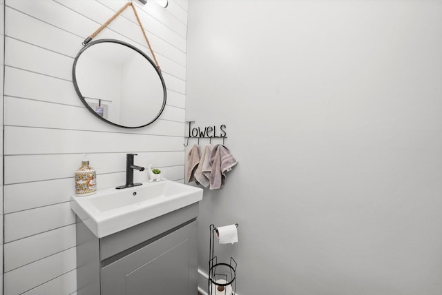 bathroom featuring wood walls and vanity