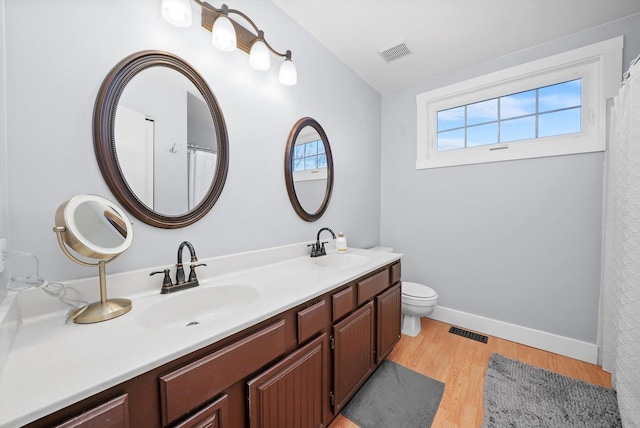 bathroom featuring hardwood / wood-style flooring, toilet, and vanity