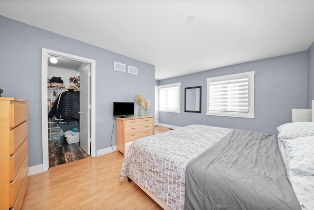 bedroom with hardwood / wood-style floors, a closet, and a walk in closet