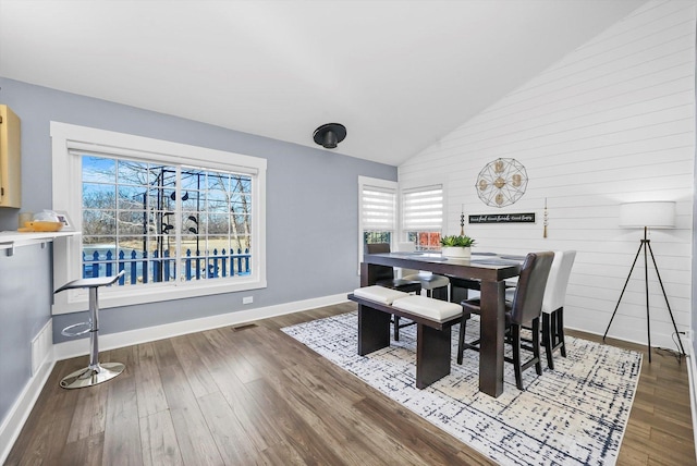 dining room with hardwood / wood-style flooring and vaulted ceiling