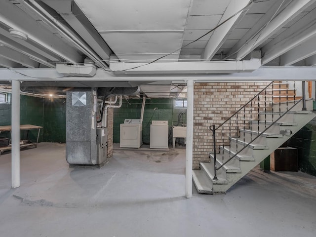 basement with heating unit, washer / clothes dryer, and sink