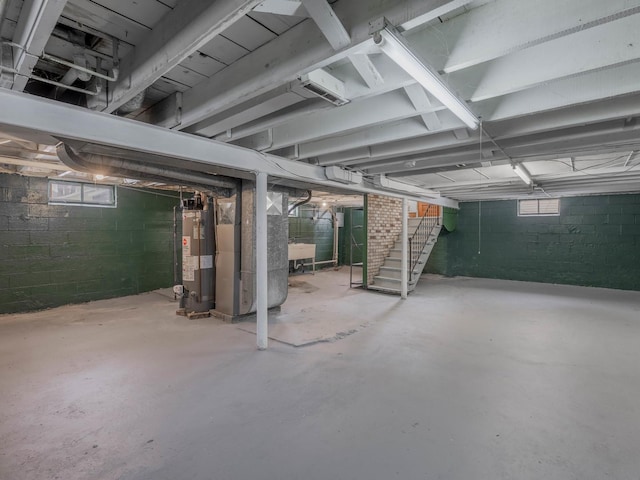 basement featuring sink, heating unit, and water heater