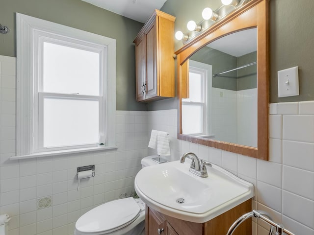 bathroom with toilet, tile walls, walk in shower, and vanity