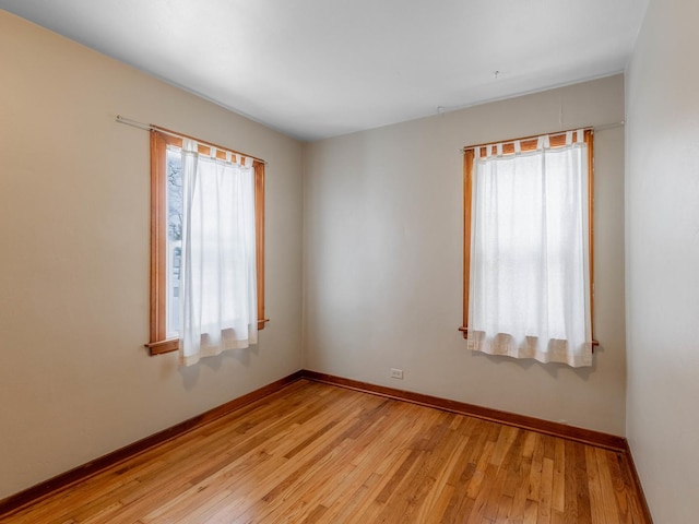 spare room with a healthy amount of sunlight and light hardwood / wood-style floors