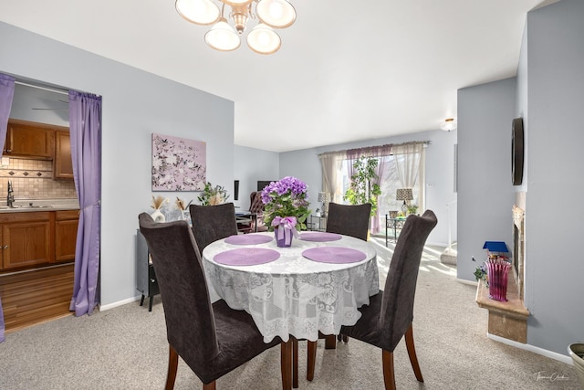 carpeted dining area with sink and a chandelier