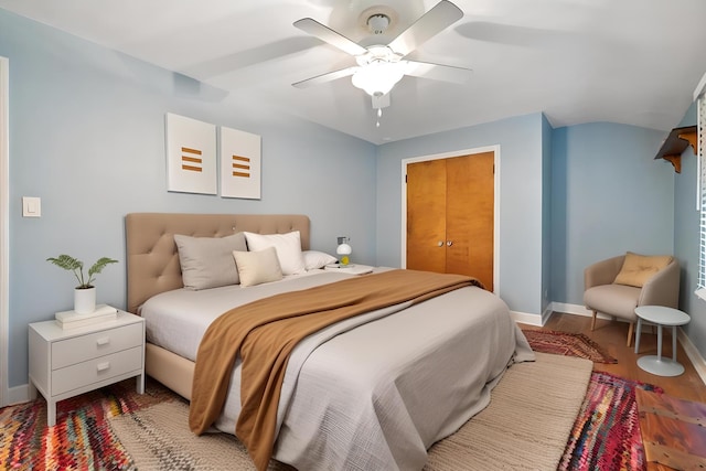 bedroom with ceiling fan, a closet, and wood-type flooring