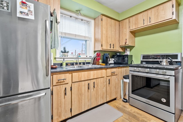 kitchen featuring light brown cabinetry, appliances with stainless steel finishes, sink, and light hardwood / wood-style floors