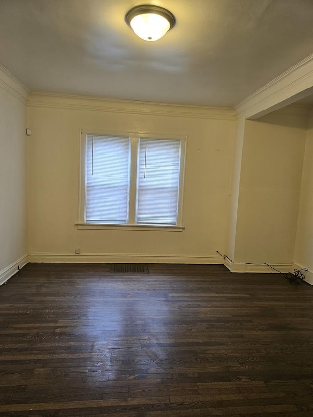 empty room with crown molding and dark hardwood / wood-style flooring