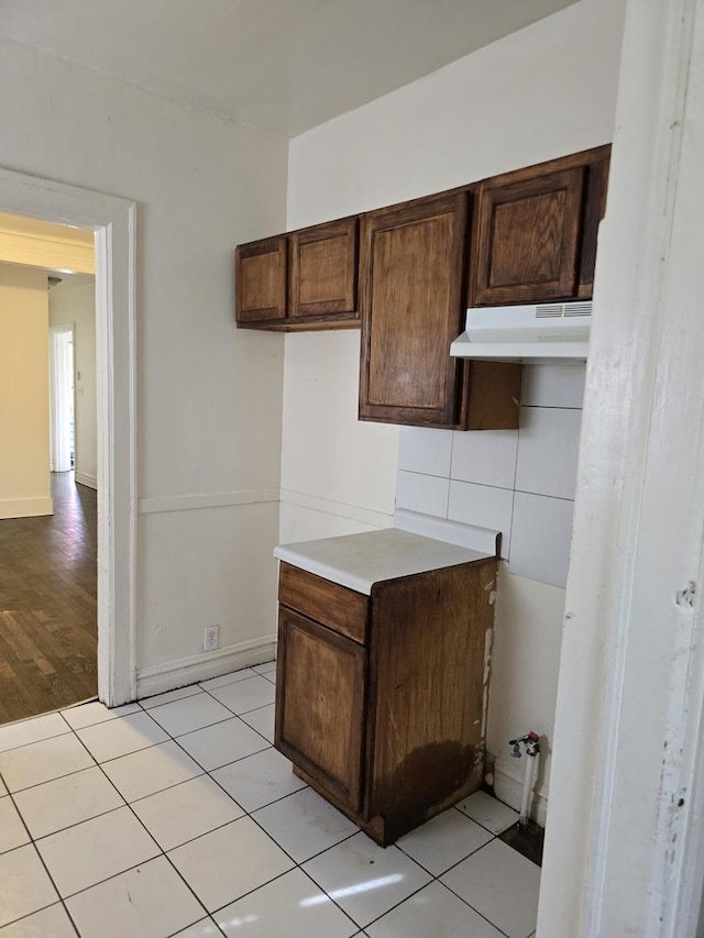 kitchen featuring dark brown cabinetry and light tile patterned floors