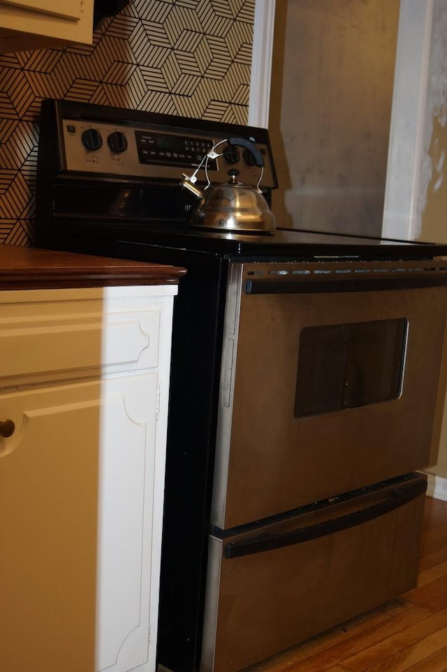 kitchen featuring wood-type flooring and electric range