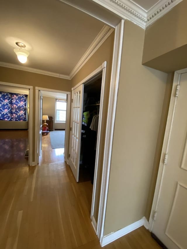 hallway with hardwood / wood-style flooring, crown molding, and french doors