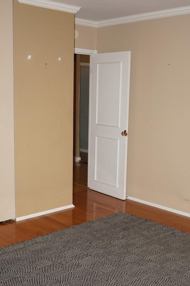 empty room with crown molding and hardwood / wood-style floors