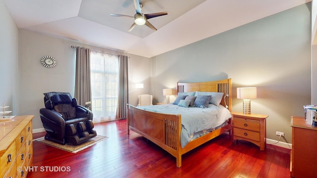 bedroom featuring ceiling fan, lofted ceiling, dark hardwood / wood-style flooring, and a raised ceiling