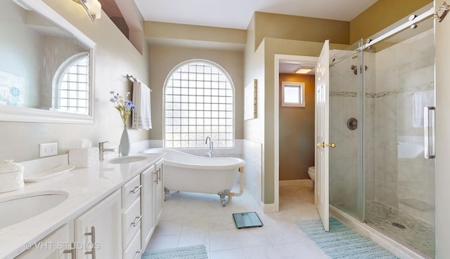 full bathroom featuring a wealth of natural light, tile patterned floors, vanity, and independent shower and bath