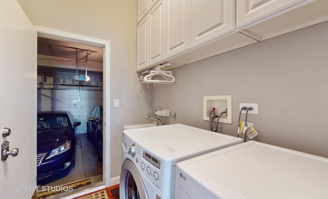 clothes washing area featuring sink, separate washer and dryer, and cabinets