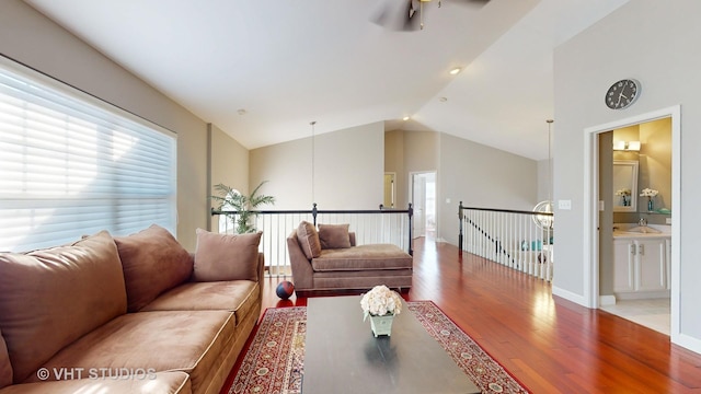 living room with lofted ceiling, hardwood / wood-style floors, and sink