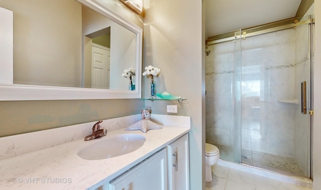 bathroom with a shower with door, tile patterned floors, toilet, and vanity