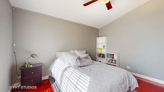 bedroom with ceiling fan, dark hardwood / wood-style flooring, and vaulted ceiling