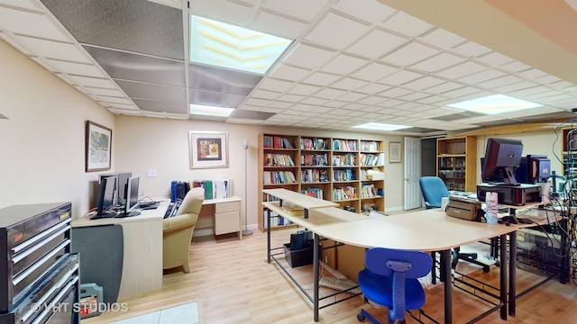 home office featuring a paneled ceiling and light wood-type flooring